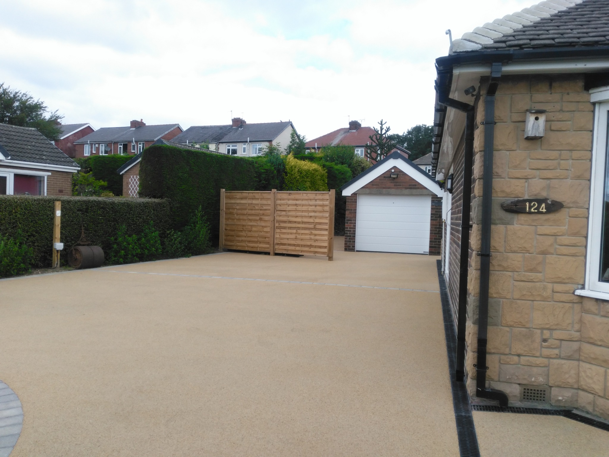 Wide level-access driveway connecting the bungalow and detached garage