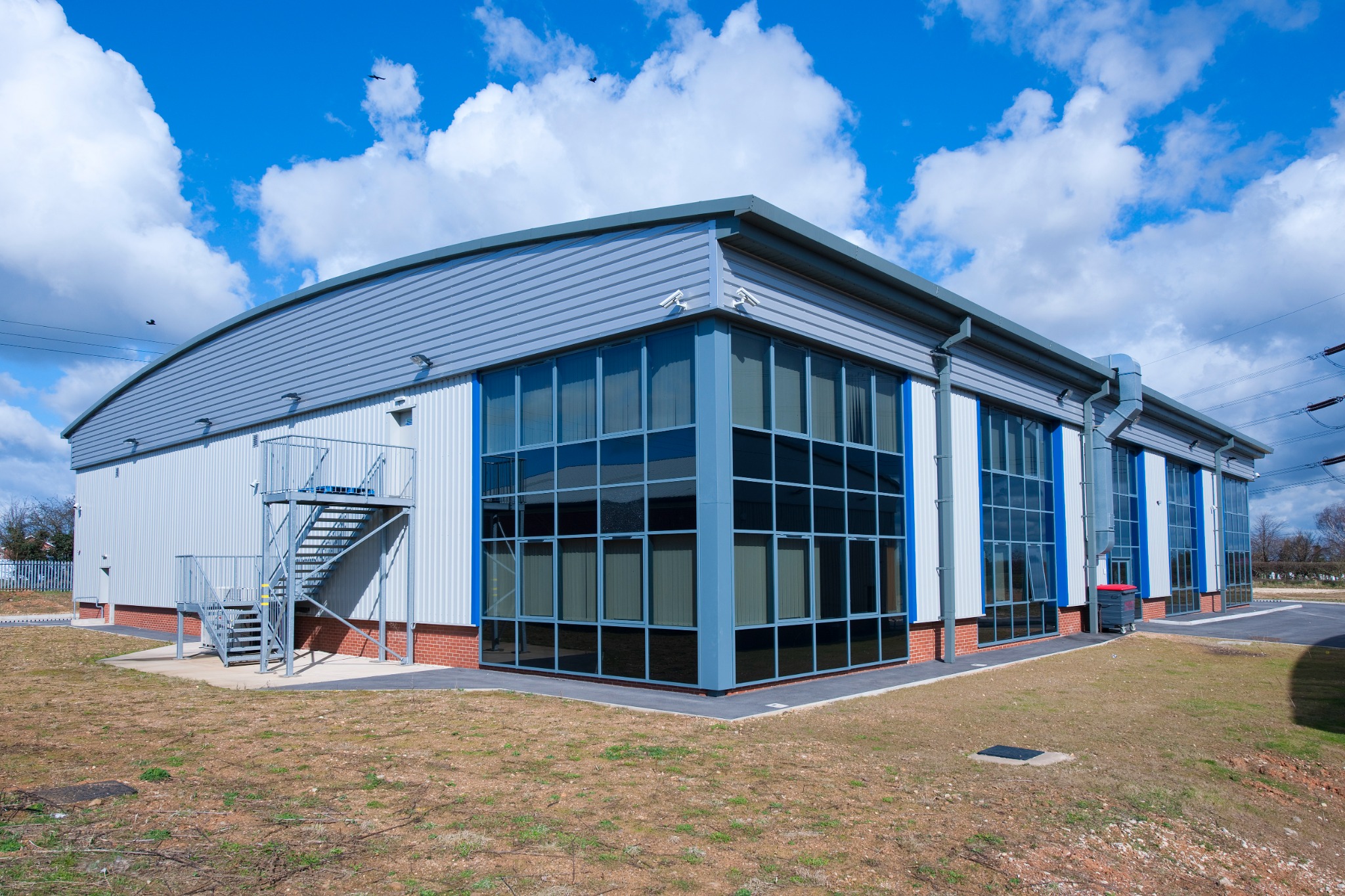 Distinctive curved roof and full-height glazed elevation