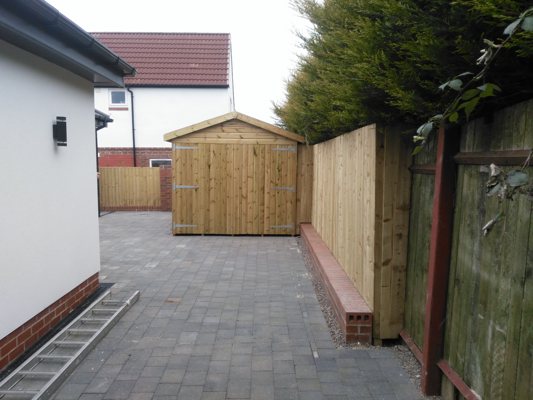 Paved level-access route and secure service area beside the extension