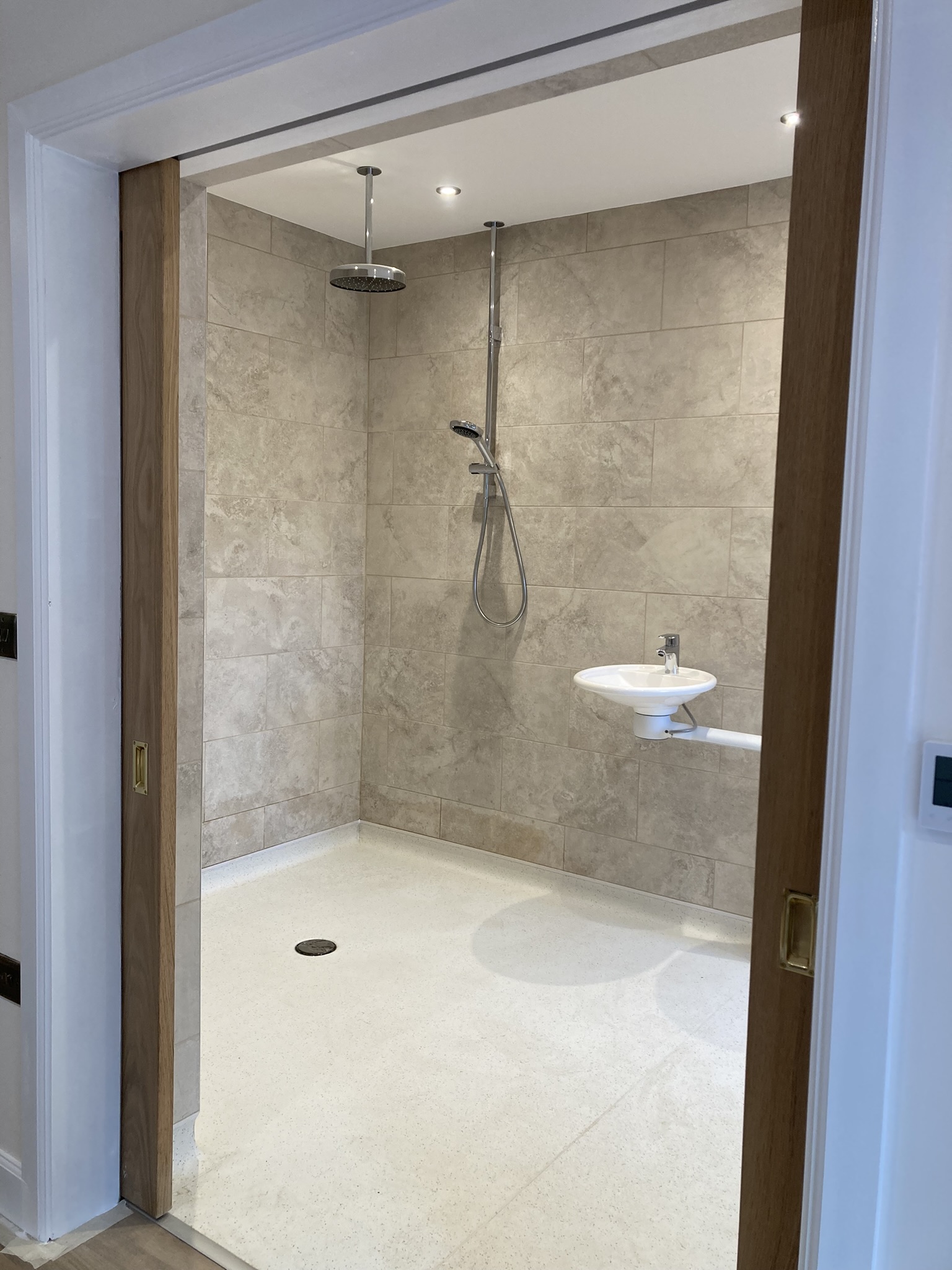 Level-access wet room with wide sliding entrance