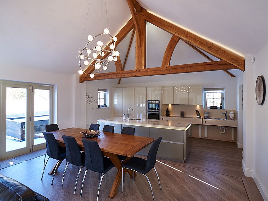 Open-plan kitchen and dining space with exposed timber trusses