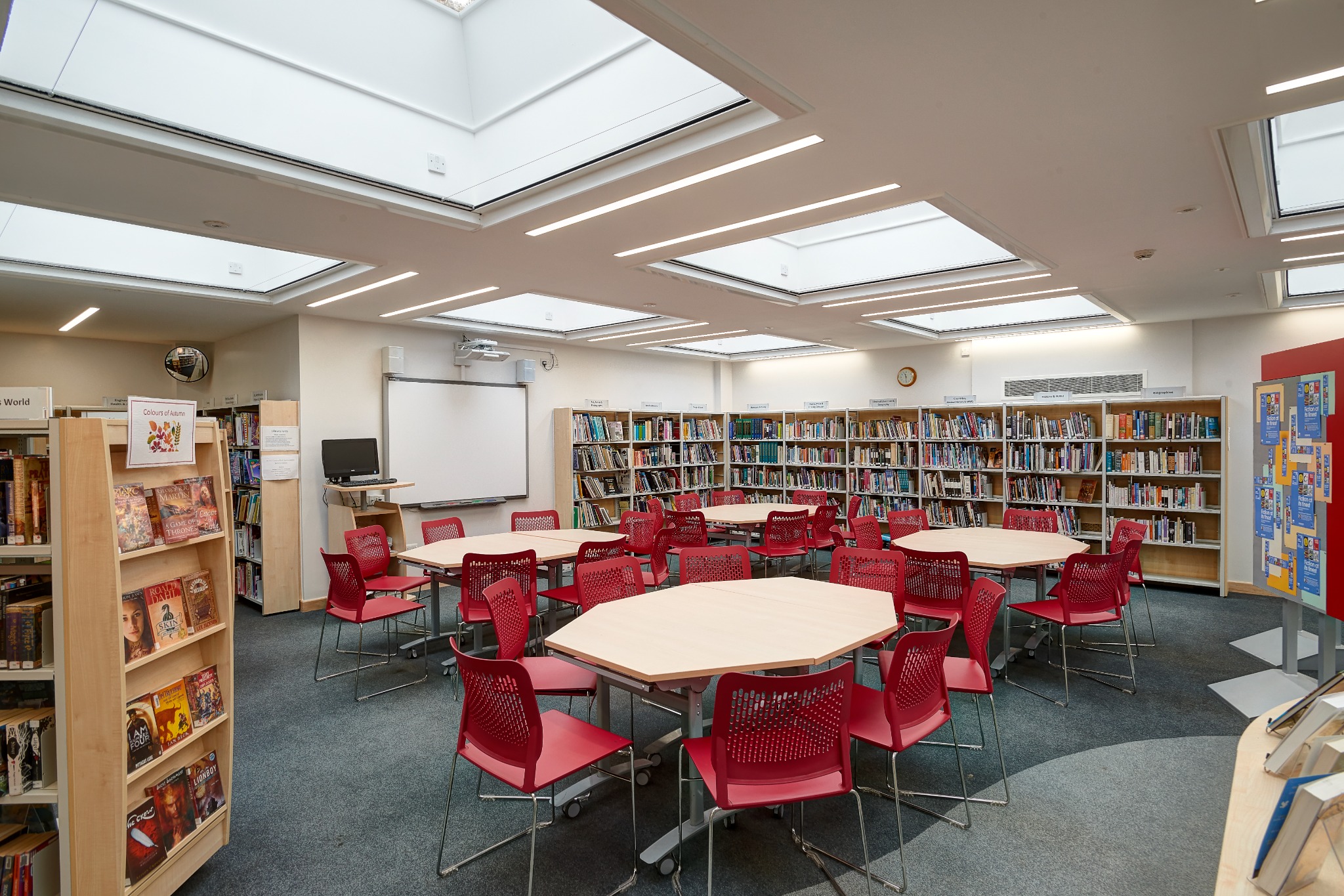Bright school library with study tables and modern shelving