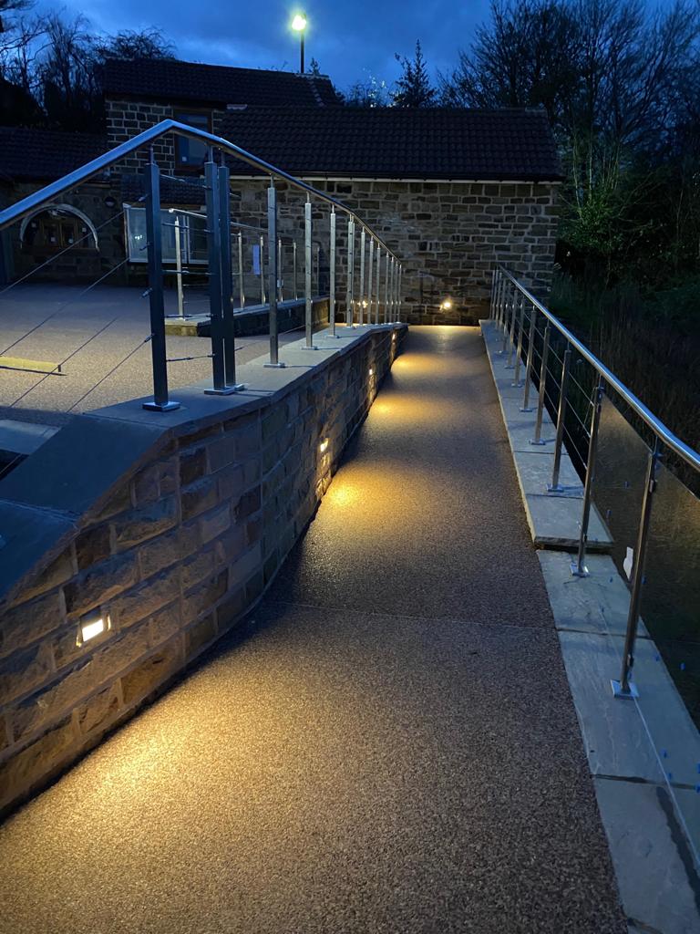 Accessible hillside route with glass balustrades and integrated lighting